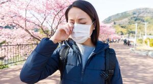 a Woman suffer from allergy from pollen allergy at sakura season